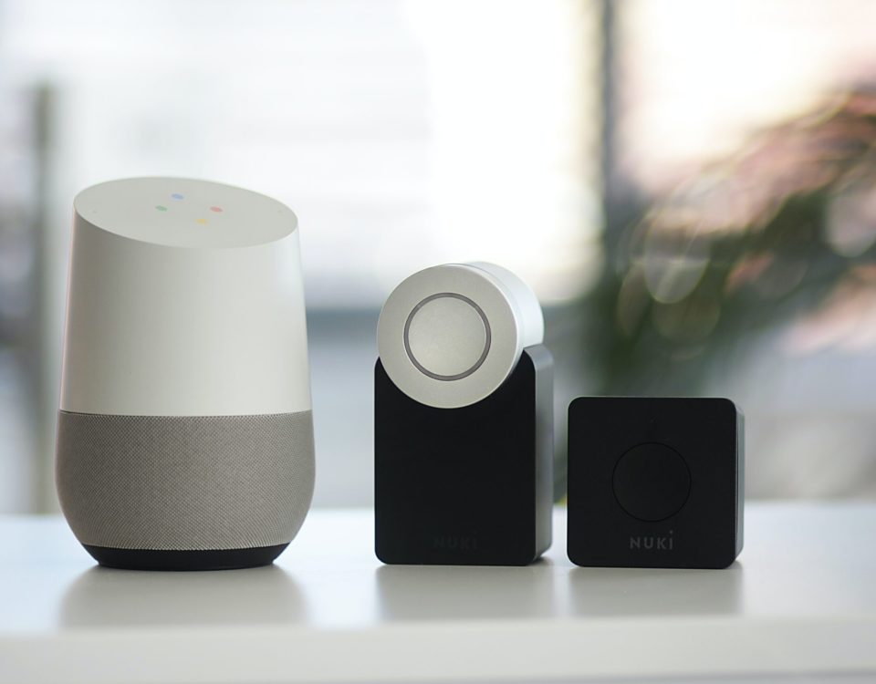 white and gray Google smart speaker and two black speakers